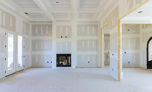 Spacious room under construction with fully installed drywall, ready for finishing, illustrating 24/7 repair services.